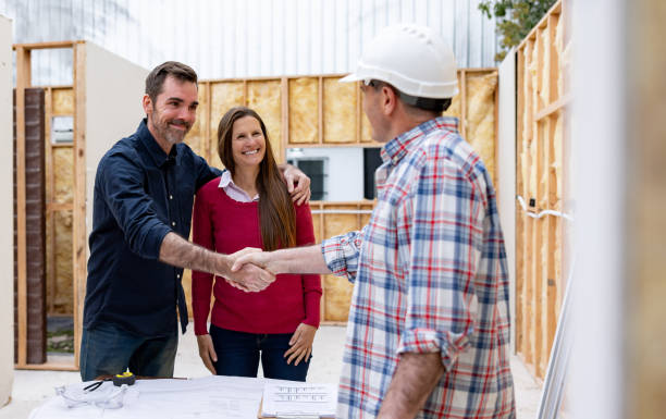 Happy couple shaking hands with the architect at a construction site, showcasing general contractor services for home renovations in San Mateo.