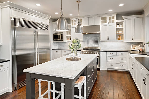 A modern kitchen featuring sleek white cabinets paired with elegant black countertops, showcasing expert bathroom remodeling service and complete home remodeling in Tiburon, CA by Tycon Builders Inc.