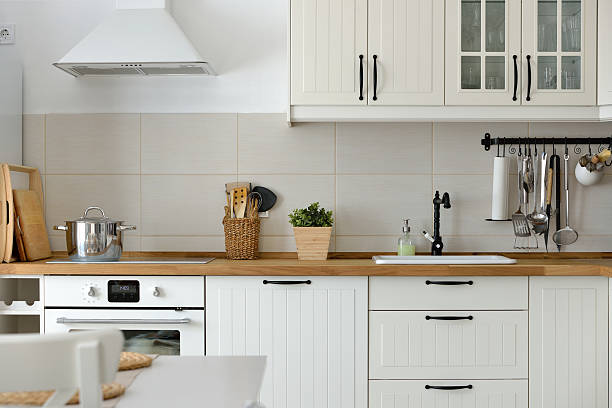 A modern kitchen featuring white cabinets, a warm wooden countertop, and custom kitchen design, creating a bright and inviting atmosphere in San Mateo.