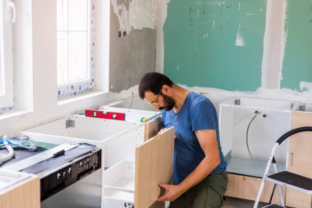 Hillsborough kitchen remodeling: Mature man installing furniture in a domestic kitchen.