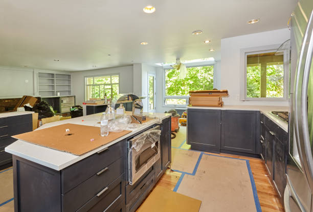 A modern kitchen featuring a refrigerator, stove, and sink, showcasing a functional and organized cooking space for custom kitchen remodeling.